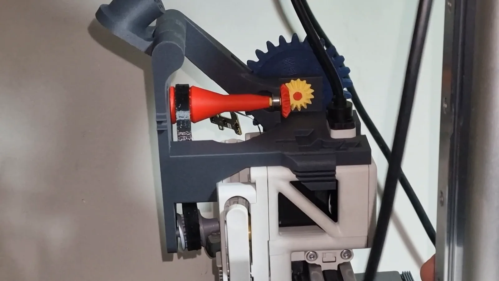 The Mechams mechanism on the printer's toolhead from the side, with the belt and the bevel gears visible