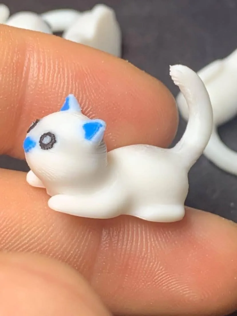 A tiny three-colour cat print on a fingertip, printed with Mechams V1 by a community member